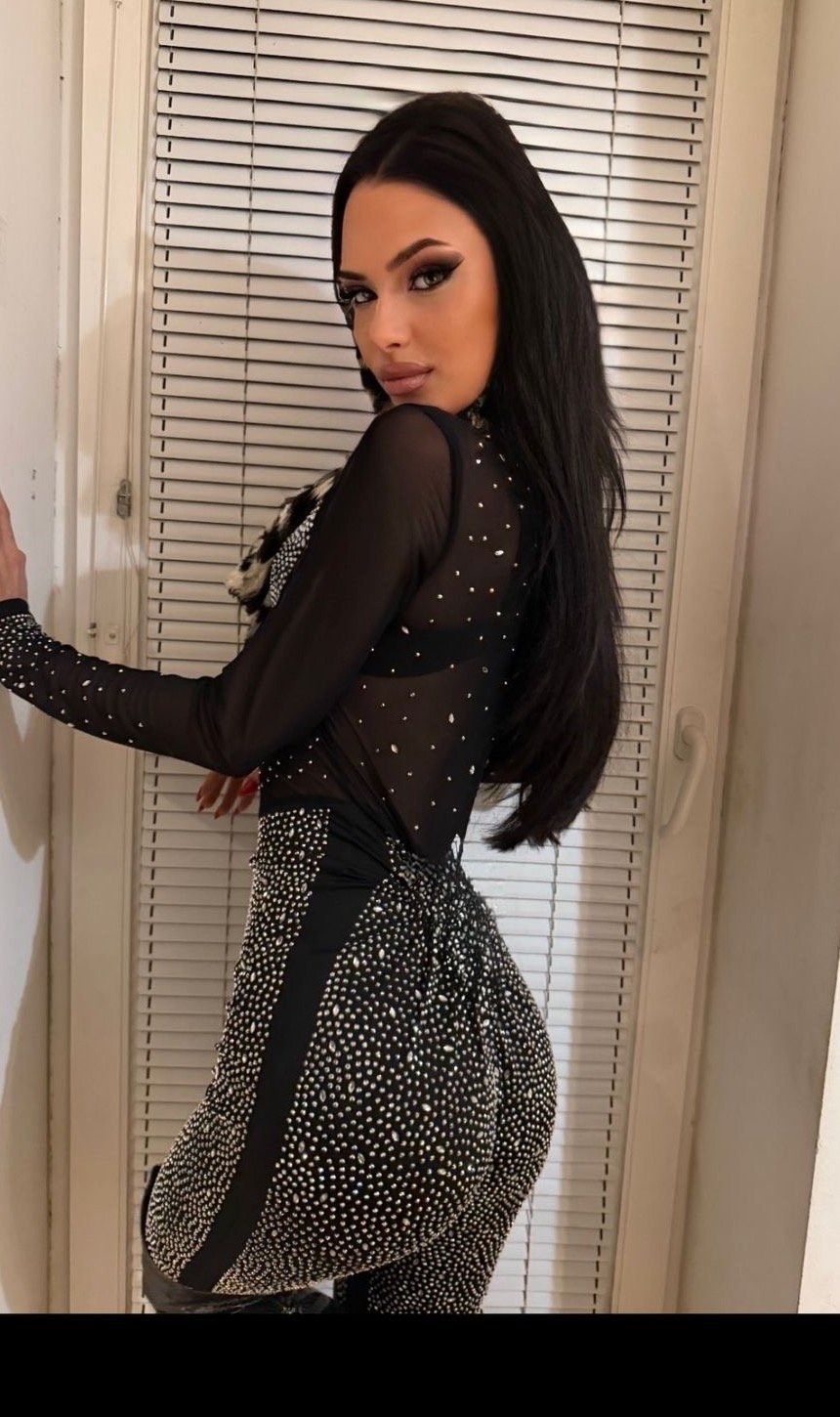 Lana Bajc posing in a sheer embellished black dress.